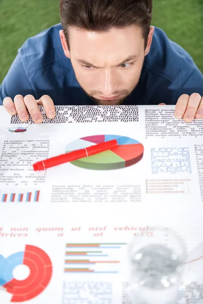 Hombre de negocios mirando documentos con gráficos y diagramas - foto de stock