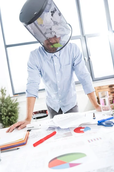 Hombre de negocios con cubo de basura en la cabeza - foto de stock