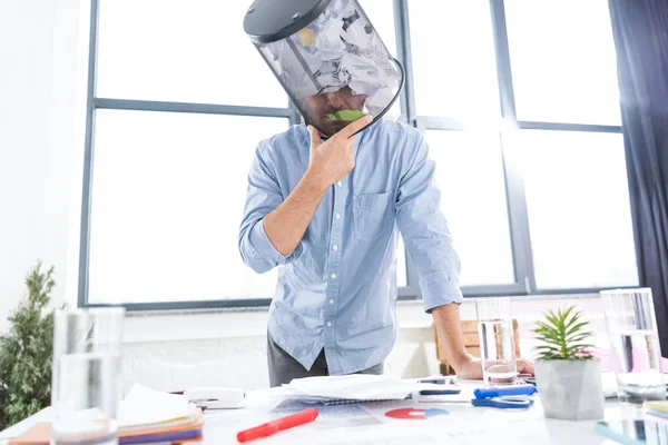 Hombre de negocios con cubo de basura en la cabeza - foto de stock