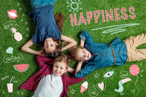 Feliz tres amigos acostados en la hierba — Stock Photo