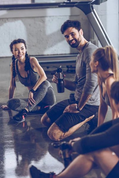 Gente deportiva descansando en el gimnasio - foto de stock