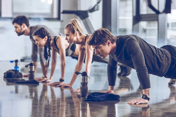 Deportistas haciendo ejercicio en el gimnasio — Stock Photo