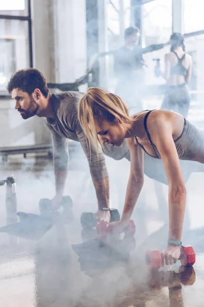 Deportistas haciendo ejercicio en el gimnasio - foto de stock