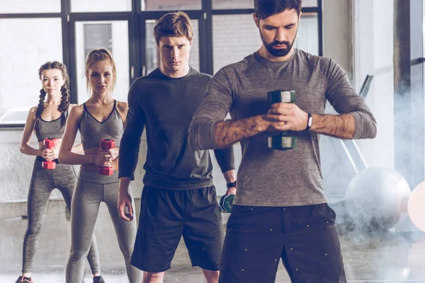 Deportistas haciendo ejercicio en el gimnasio - foto de stock