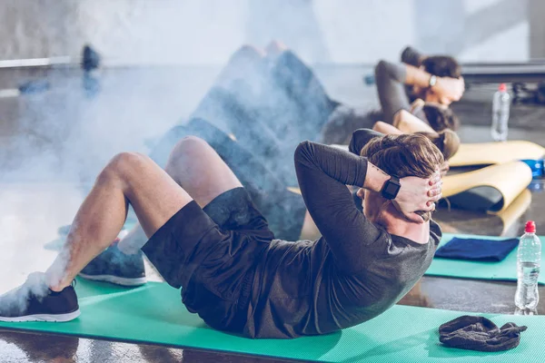 Deportistas haciendo ejercicio en el gimnasio - foto de stock