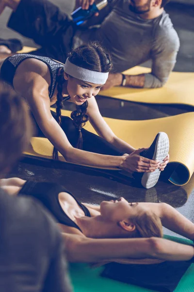 Athletic young people exercising in gym — Stock Photo