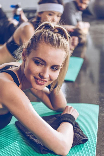 Athletic young people exercising in gym — Stock Photo