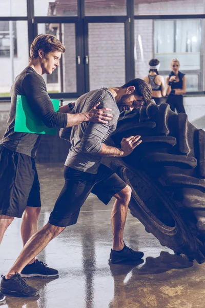 Homme tirant pneu dans la salle de gym — Photo de stock