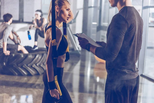 Sportive woman with trx equipment — Stock Photo