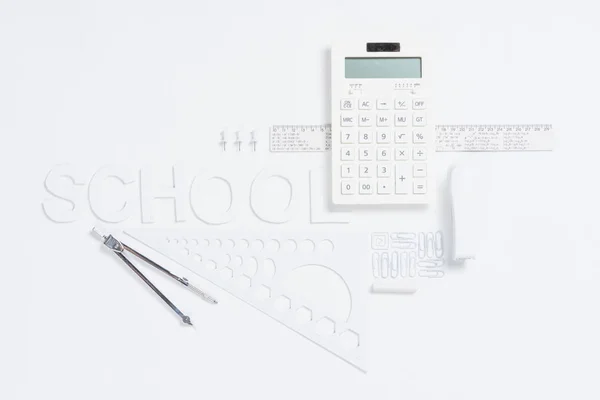 Calculator with rulers and stapler with compasses — Stock Photo