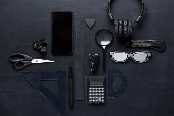 Smartphone con varios utensilios de oficina - foto de stock