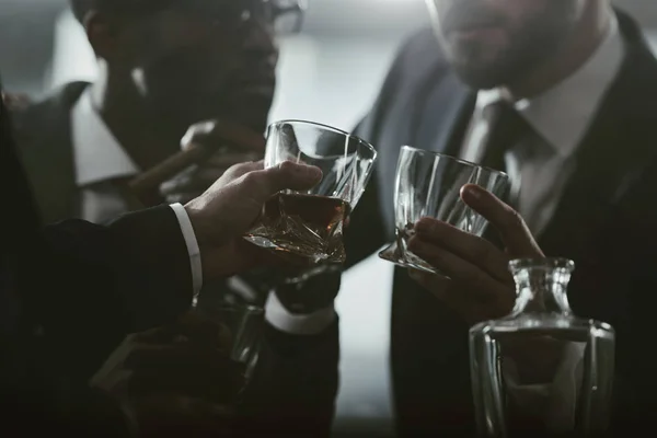 Vista recortada del equipo de negocios pasar tiempo y beber whisky - foto de stock