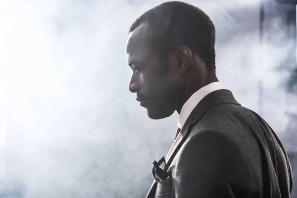 Retrato de perfil del empresario afroamericano confiado en traje mirando hacia otro lado - foto de stock