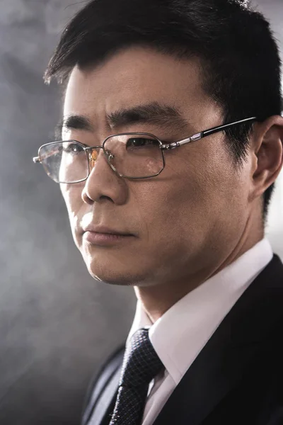 Retrato de confiante asiático empresário em óculos olhando para longe — Fotografia de Stock