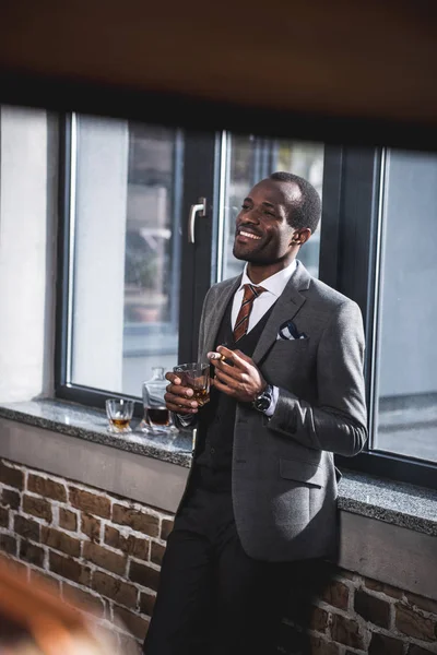 Selbstbewusster Geschäftsmann mit Zigarre und Glas Alkohol in der Hand — Stockfoto