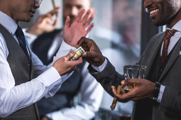 Seitenansicht eines Geschäftsmannes, der lächelnden Kollegen Geld gibt — Stockfoto