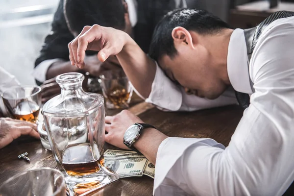 Пьяные коллеги спят за столом, проводя время вместе после работы — стоковое фото