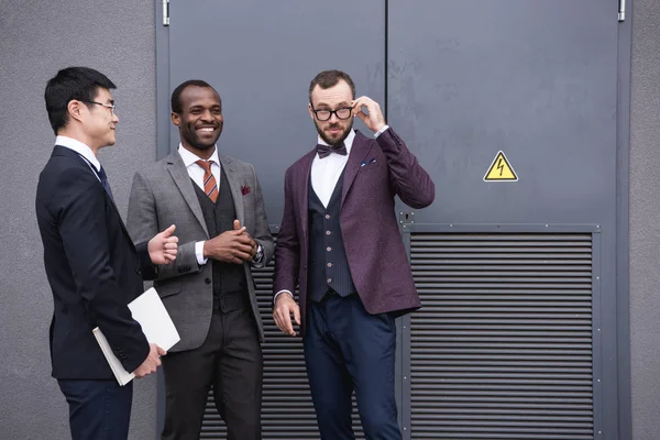 Команда мультикультурных предпринимателей обсуждает совместную работу возле современного офисного здания — стоковое фото