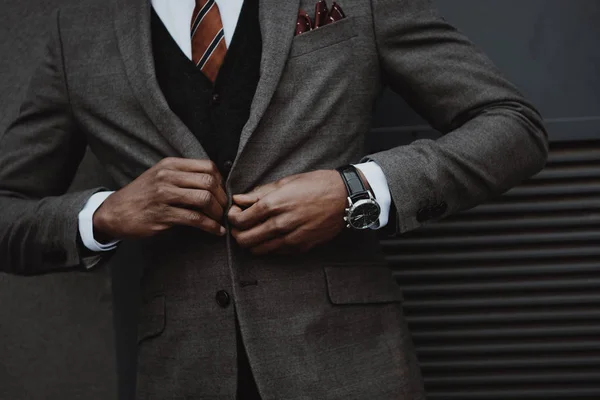 Confiado hombre de negocios elegante con traje al aire libre en la pared - foto de stock