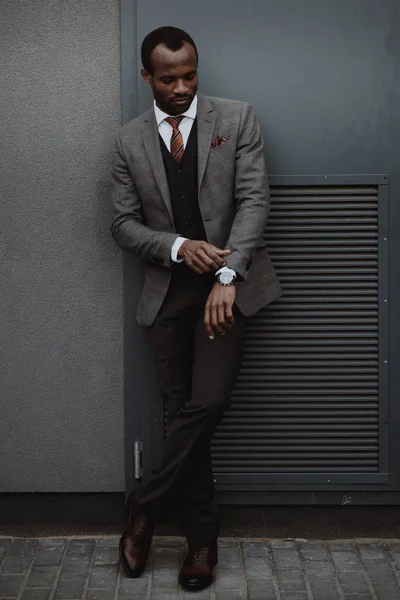 Selbstbewusst stylischer afrikanisch-amerikanischer Geschäftsmann posiert draußen an der Wand — Stockfoto