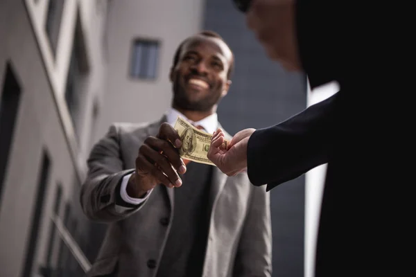 Young african american businessman in formalwear taking money outdoors — Stock Photo