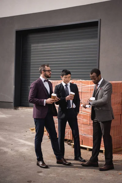 Young multiethnic businessmen in formalwear meeting at coffee break outdoors, business team meeting — Stock Photo