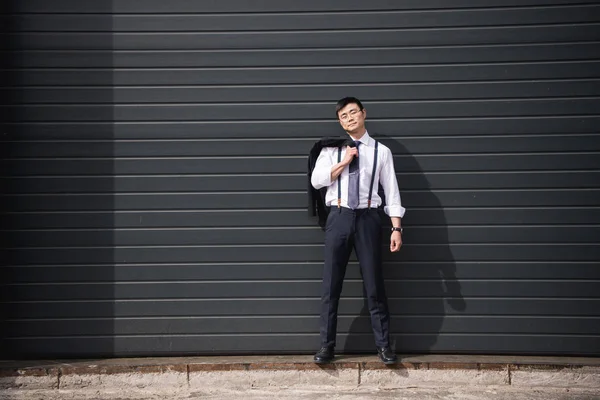 Молодой уверенный азиатский бизнесмен, стоящий на улице с копировальным пространством — стоковое фото