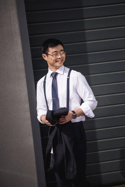 Young stylish asian businessman in glasses standing outdoors — Stock Photo