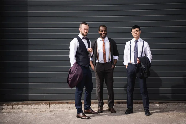 Молодий стильний багатонаціональний бізнесмен у формальному одязі, що стоїть на відкритому повітрі, зустріч ділової команди — стокове фото