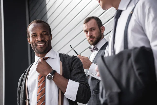 Jovem elegante homens de negócios multiétnicos em formalwear de pé ao ar livre, reunião de equipe de negócios — Fotografia de Stock
