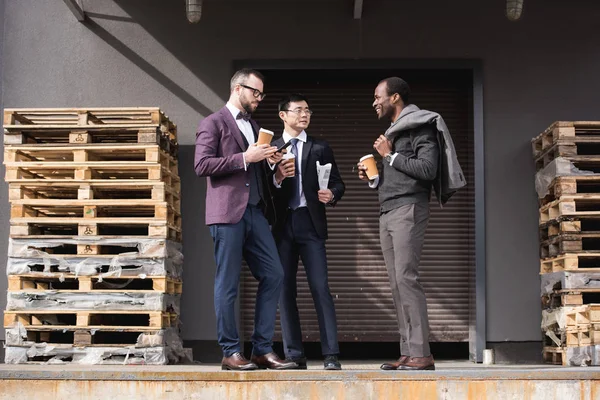 Jóvenes empresarios multiétnicos en formalwear reunión en coffee break al aire libre, reunión del equipo de negocios - foto de stock