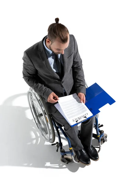Hombre de negocios en silla de ruedas mirando el contrato - foto de stock
