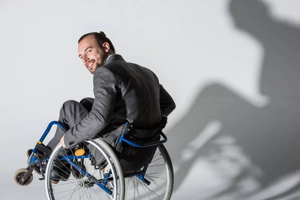 Физически неполноценный бизнесмен в инвалидной коляске с тенью — стоковое фото