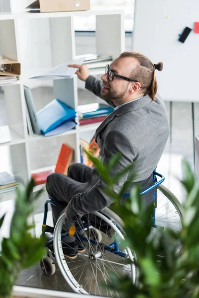 Hombre de negocios físicamente discapacitado haciendo papeleo - foto de stock