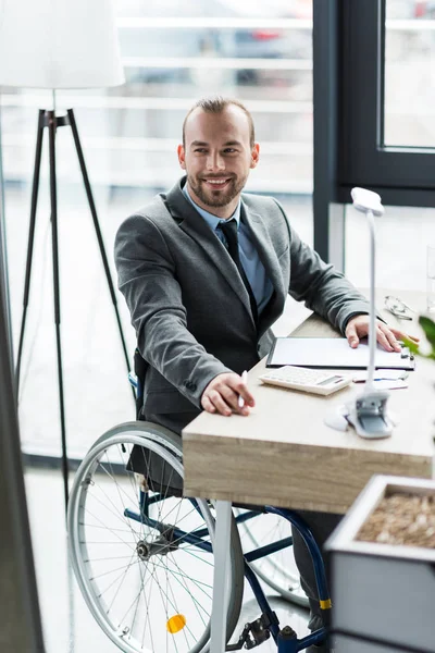 Hombre de negocios con discapacidad física en traje en la oficina - foto de stock