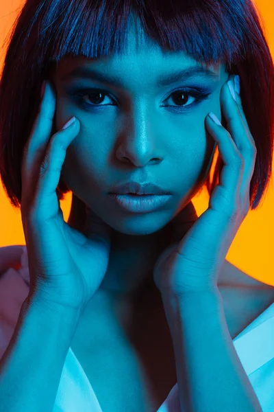 Mujer afroamericana con las manos en la cara - foto de stock