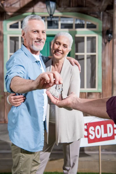 Saleman giving keys to new owners — Stock Photo