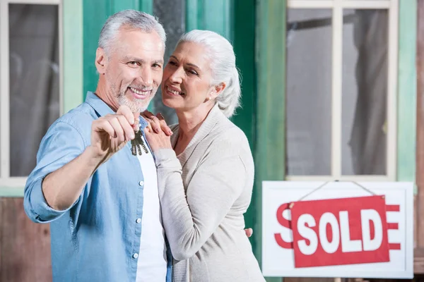 Pareja mayor con nuevas llaves de la casa - foto de stock