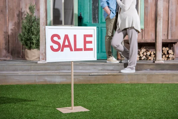 Senior couple near house for sale — Stock Photo