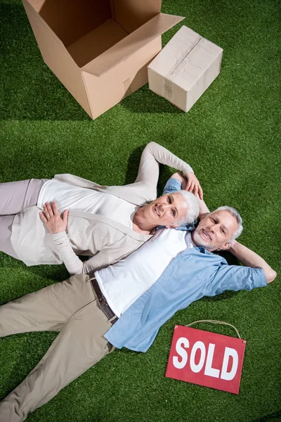 Couple âgé allongé sur l'herbe — Photo de stock