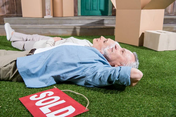 Casal sênior deitado na grama — Fotografia de Stock
