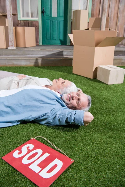 Senior couple lying on grass — Stock Photo