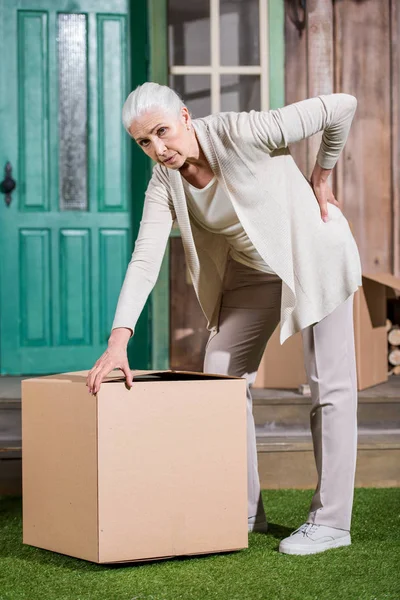 Senior woman with cardboard box — Stock Photo