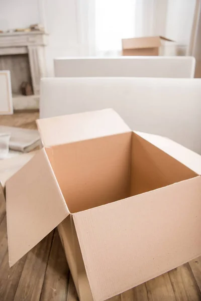 Cardboard box in empty room — Stock Photo