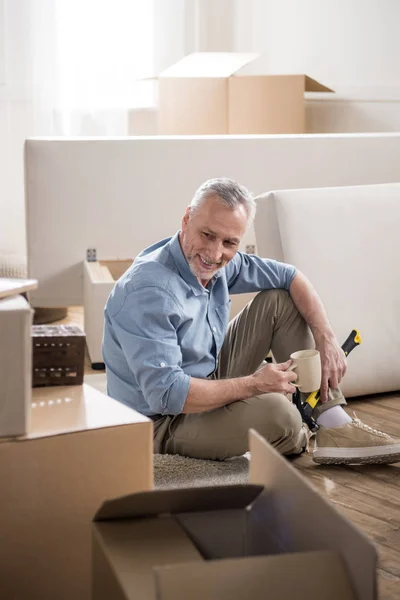 Senior man sitting and drinking coffee — Stock Photo