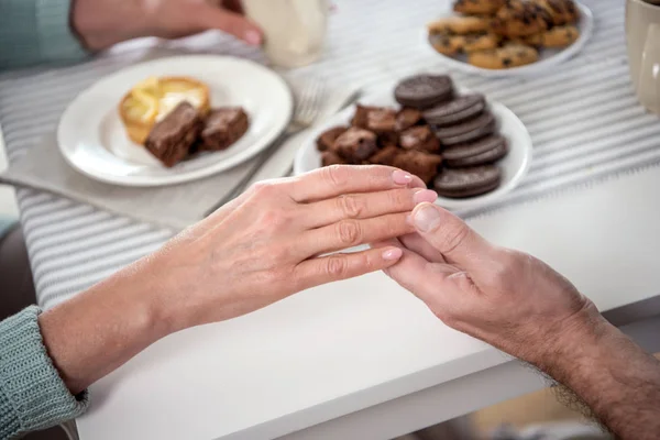 Casal de mãos dadas durante o café da manhã — Fotografia de Stock