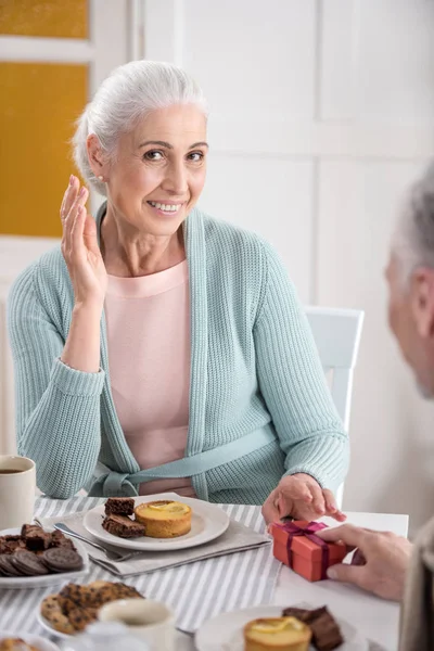 Senior homme présentant cadeau à la femme — Photo de stock