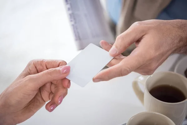 Hombre pasando la tarjeta en blanco a la mujer - foto de stock