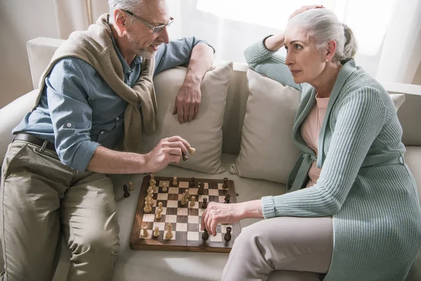 Seniorenpaar spricht beim Schachspielen — Stockfoto