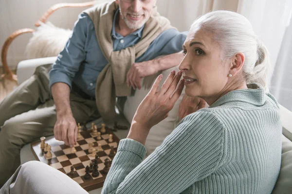Grey haired couple playing chess — Stock Photo